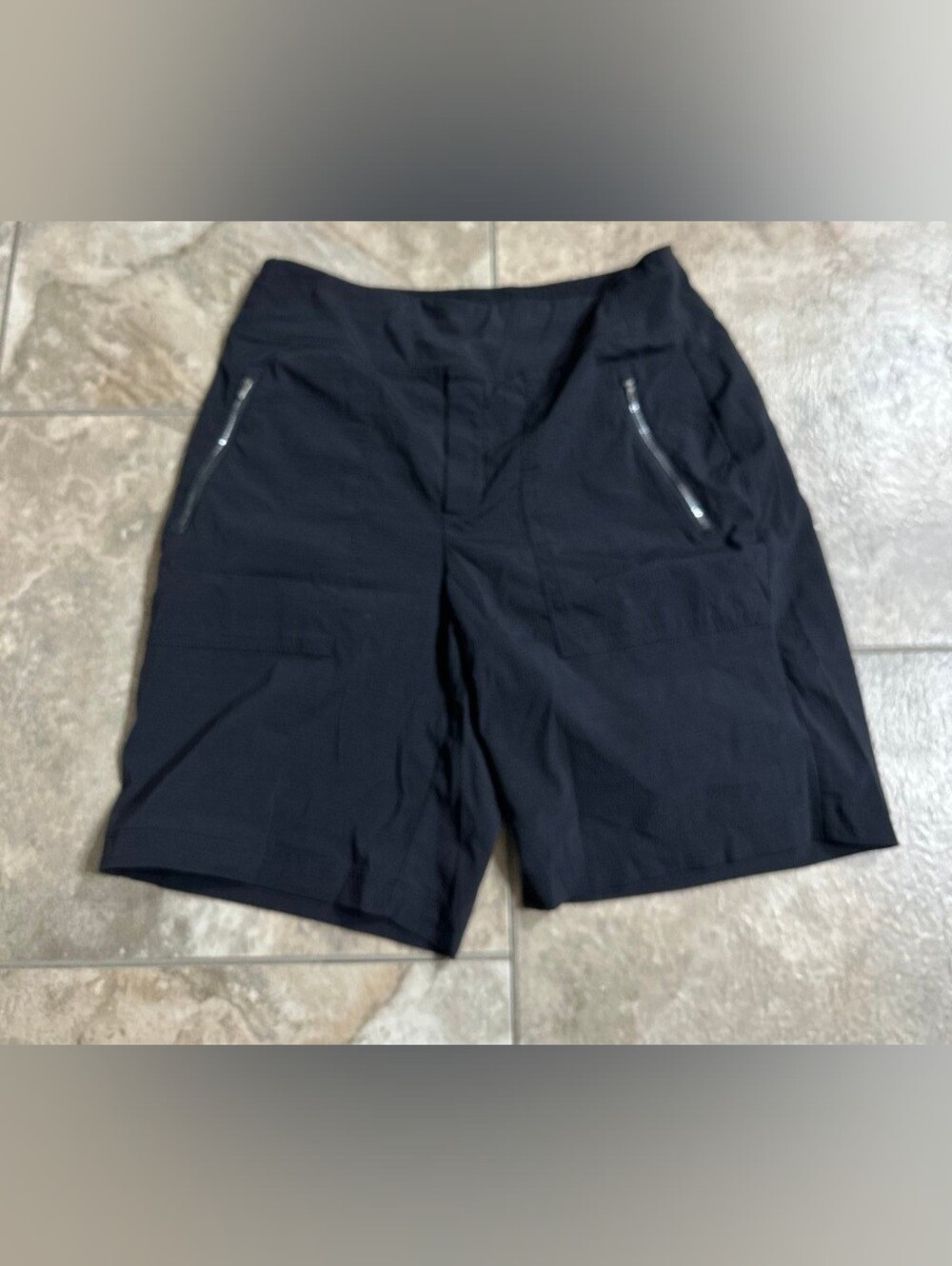 Athleta Women’s Black Performance Zip-Pocket Shorts are a size 8.